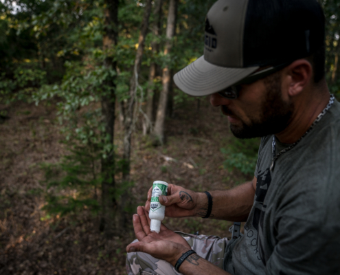 man applying an outdoor bug repellent