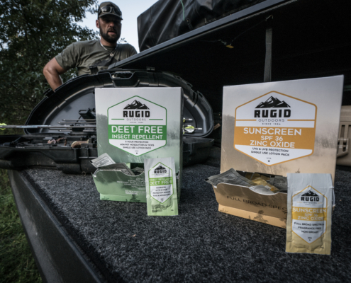 rugid single use repellent and sunscreen foil packs in a car boot