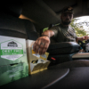man in a car reaching out to a foil pack of a rugid sunscreen